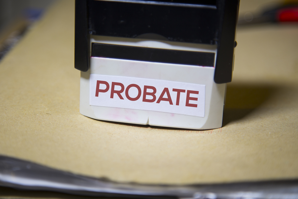 the word probate on a stamp on a big folder of paperwork