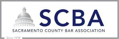 Logo of Sacramento County Bar Association featuring a gray dome and blue acronym SCBA.