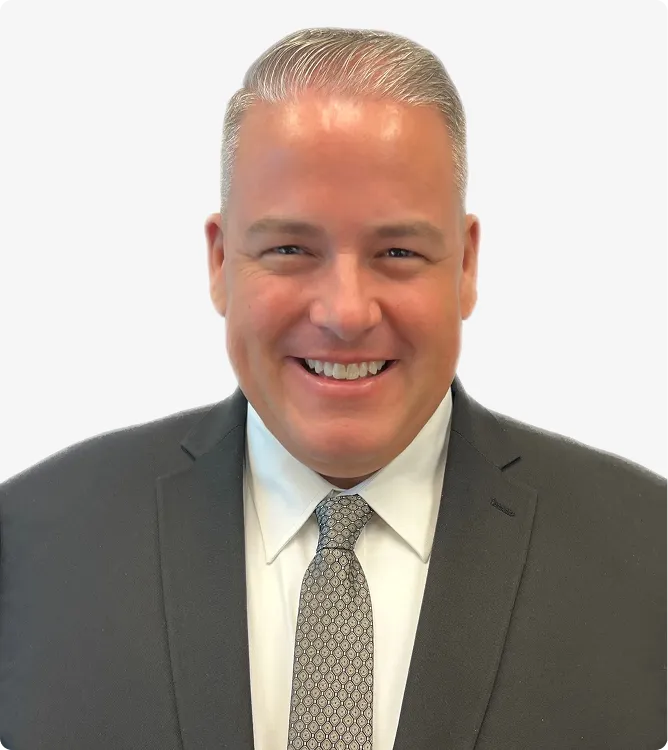 Professional portrait of a smiling man in a dark suit, white shirt, and patterned tie.