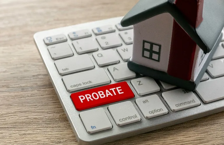 Close-up of a keyboard with a red "PROBATE" key and a small house model on top.