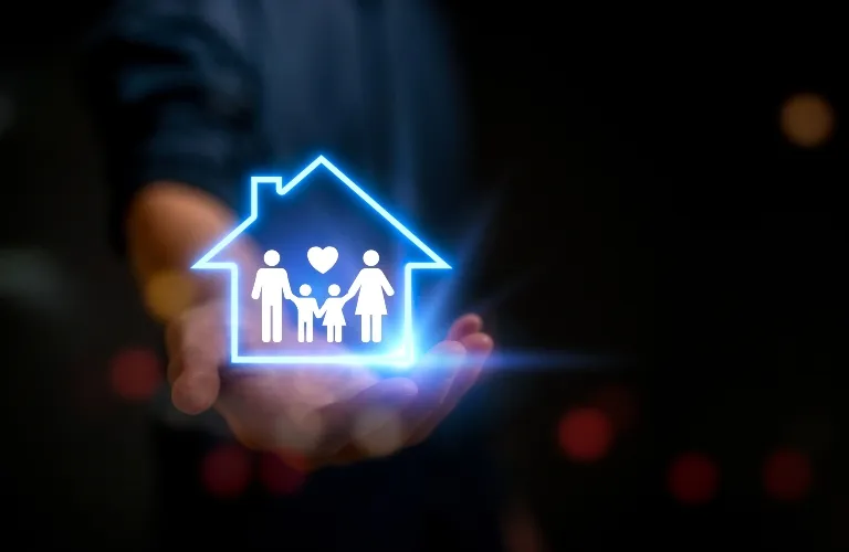 Hand holding glowing blue house icon with family figures and heart symbol inside.