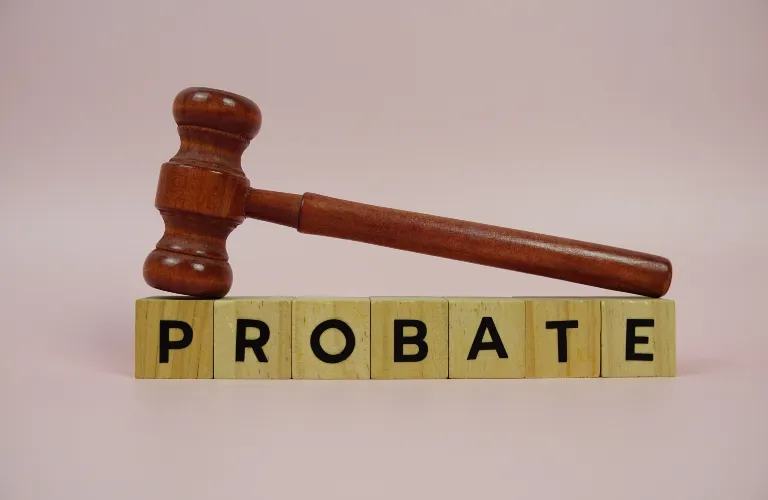 Wooden judge's gavel resting on blocks spelling the word "PROBATE" against a neutral background.